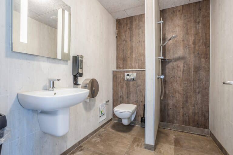 Badeværelse med håndvask, bruser og toilet